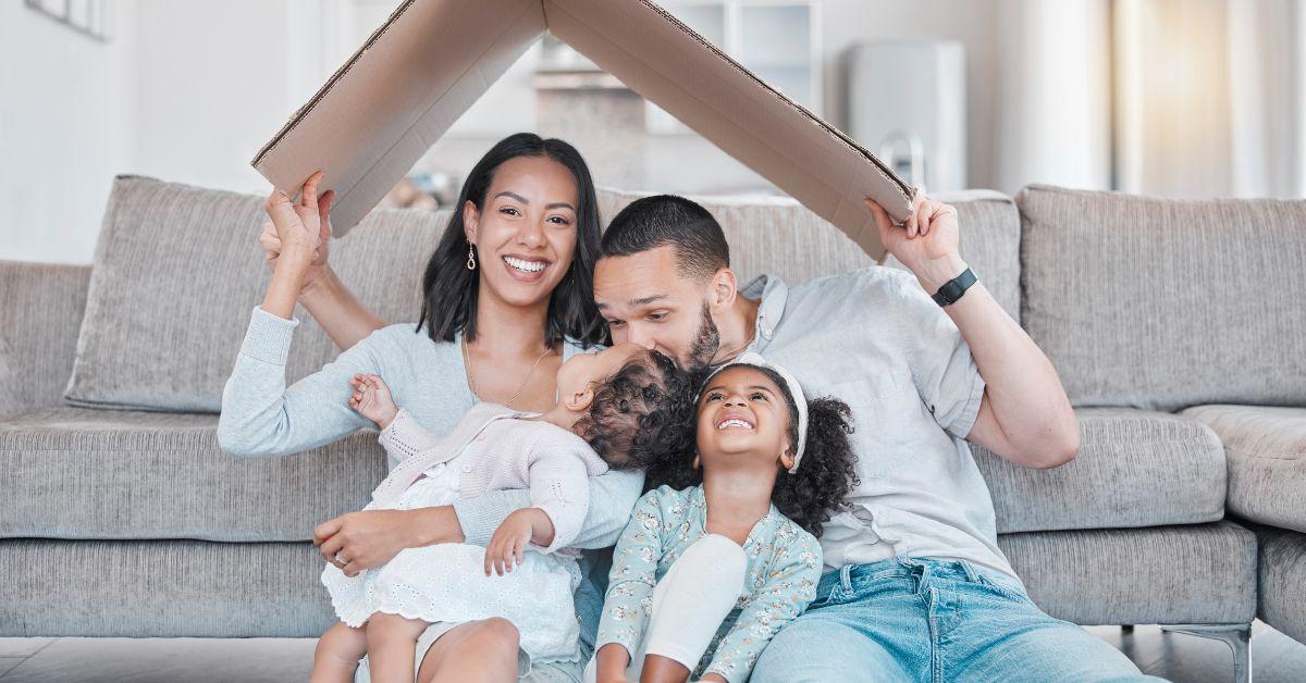 Parents embracing their two kids and smiling.