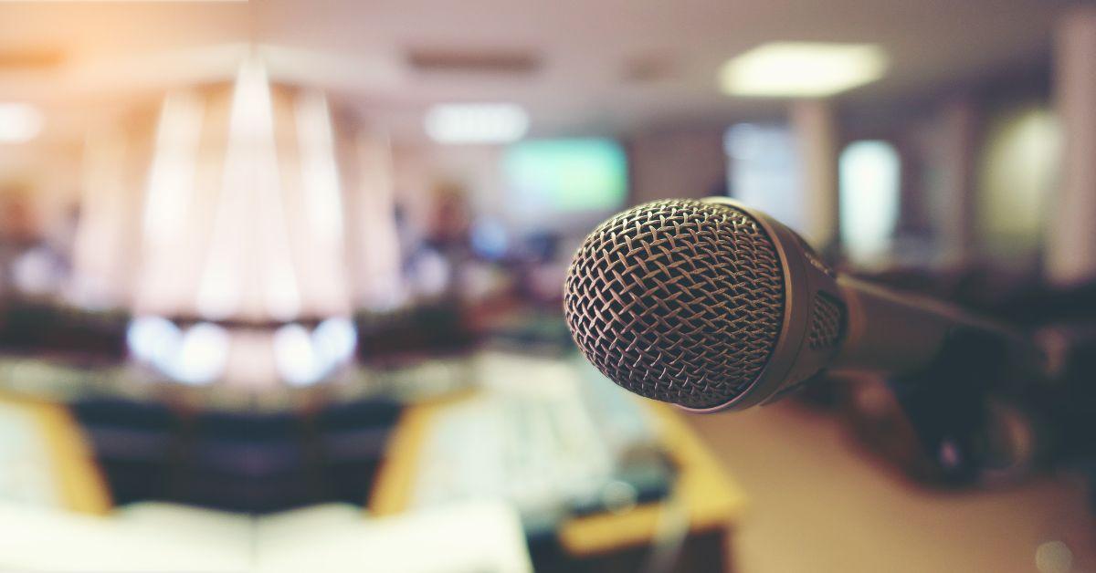 A close up of a microphone in a blurry room