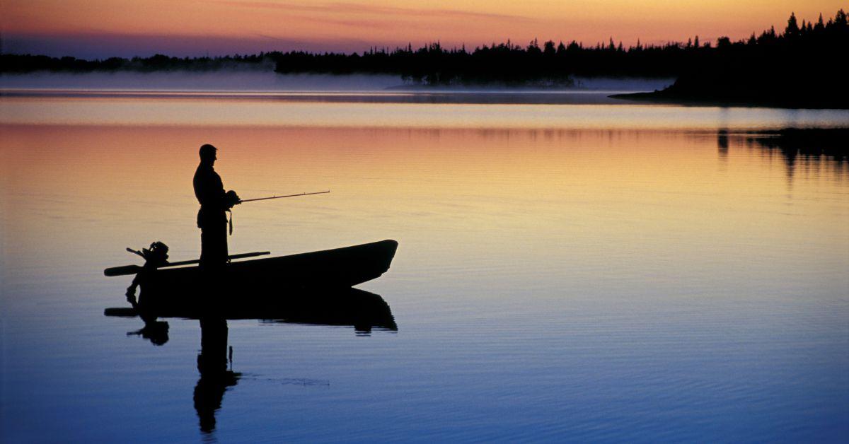 A person fishing on a lake in a boat